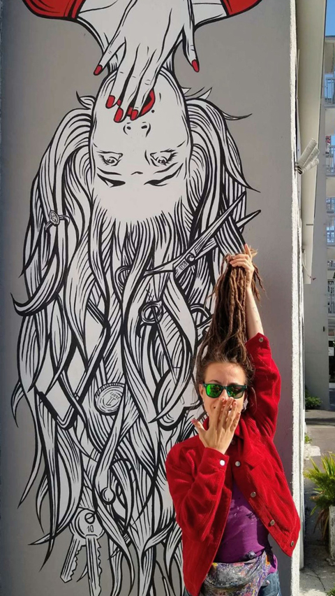 Ten minimalistyczny mural "graffiti art " został zrealizowany dla salonu fryzjerskiego, co nadaje mu dodatkowego kontekstu i symboliki związanej z włosami i stylizacją. Mural przedstawia postać kobiety namalowaną do góry nogami, co nadaje kompozycji surrealistyczny i intrygujący charakter.